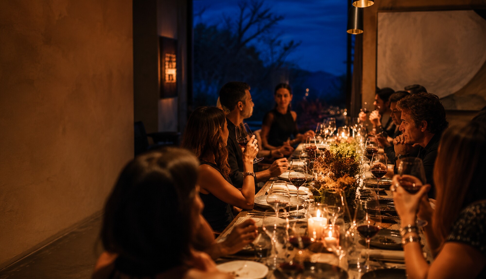 Mesa longa à luz de velas, convidados próximos
